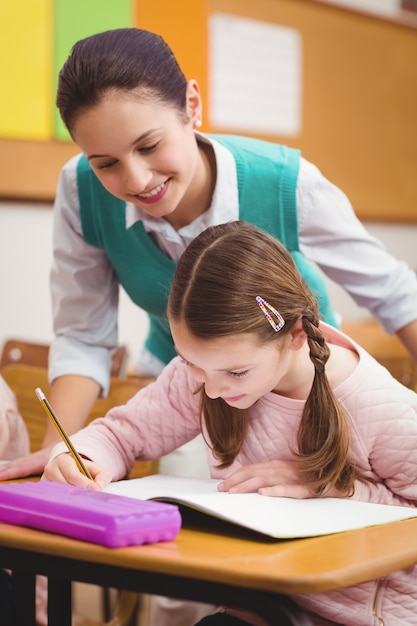 Professor ajudando uma menina durante a aula