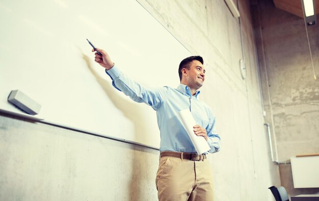 Foto professor apontando marcador para o quadro branco na palestra