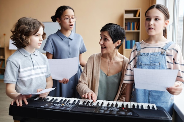 Professor cantando músicas com crianças em sala de aula