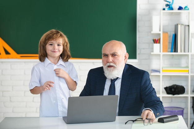 Professor com aluno em sala de aula aluno com laptop educação e aprendizado professor ajuda a aprender aulas felizes de volta à escola