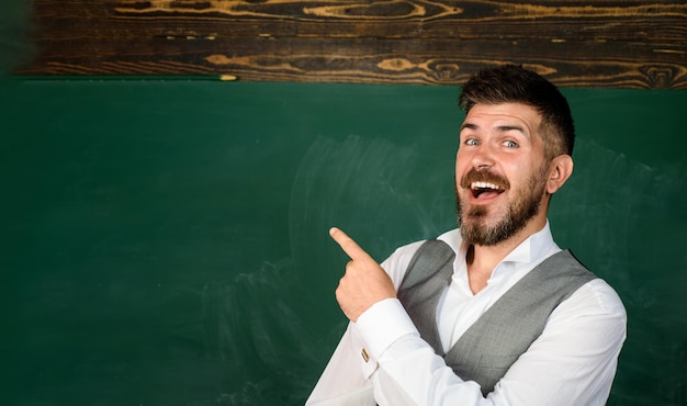 Foto professor dando aula para alunos, professor confiante do sexo masculino no ensino médio de educação em sala de aula e