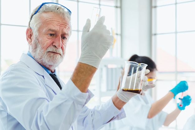 Professor de ciências e equipe de estudantes trabalhando com produtos químicos no laboratório