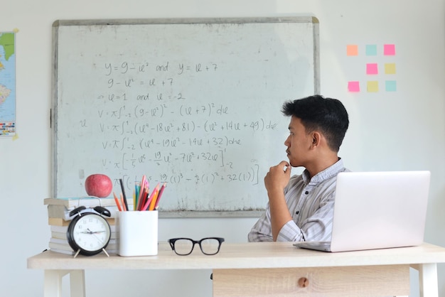 Professor do ensino médio preparando material de aula de matemática antes da aula na sala de aula