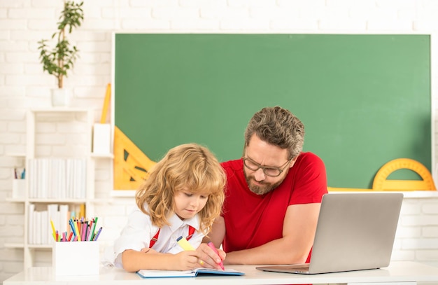 Professor e criança estudam em sala de aula com paternidade de laptop