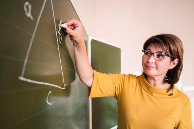 Professor escrevendo no quadro-negro