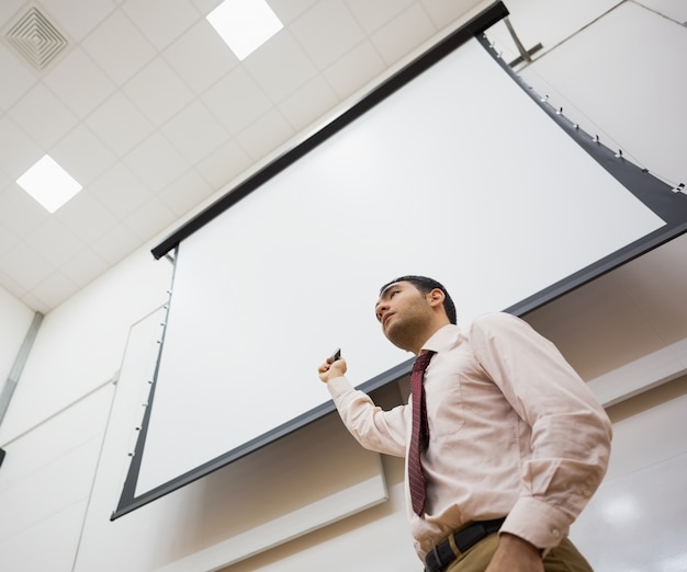 Foto professor masculino com tela de projeção na sala de aula