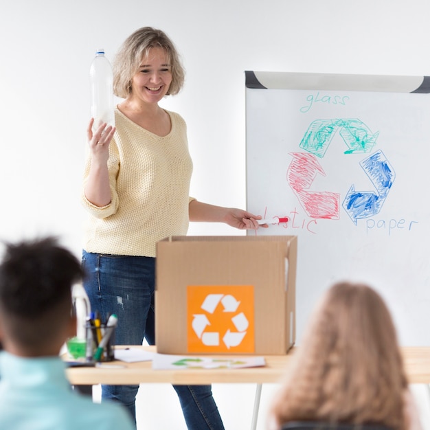 Professor, mostrando as crianças como reciclar