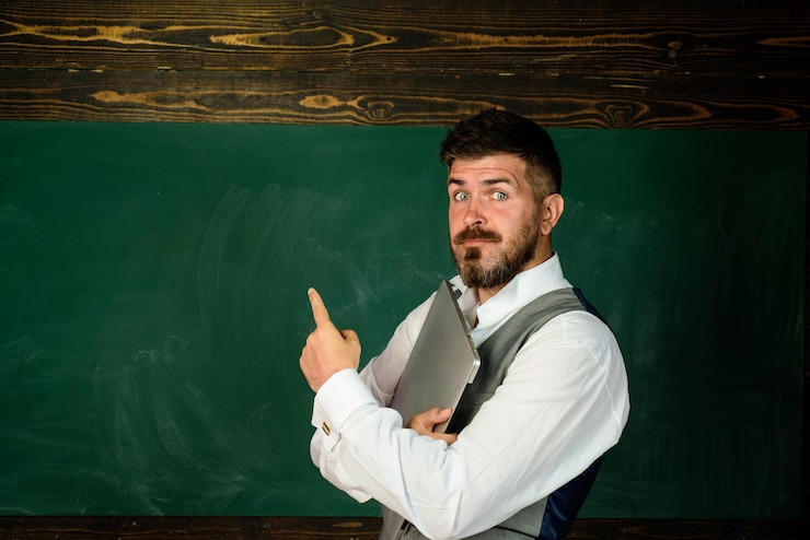 Foto professor na lição da escola em sala de aula professor de aprendizagem conceito de aprendizagem professor barbudo perto de quadro-negro