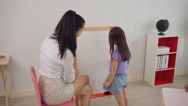 Professor pré-escolar com crianças estudam em sala de aula. jardim de infância de volta à escola