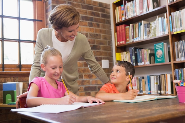 Professor que ajuda alunos na biblioteca