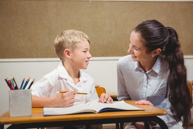 Professor que ajuda um aluno em sala de aula