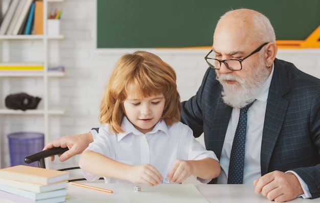 Professor sênior ou avô e aluno de escola em sala de aula na aula particular da escola velho tutor t