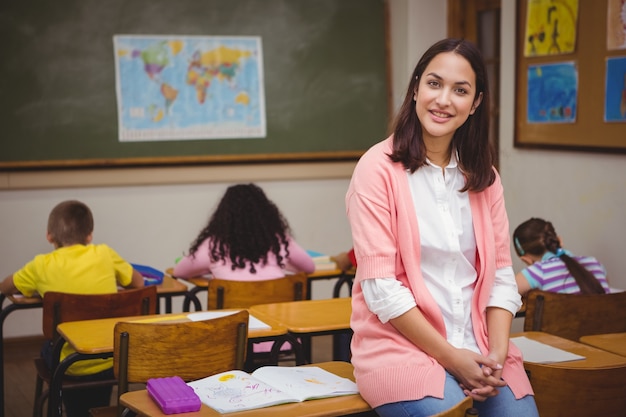 Professor sentado atrás de seus alunos