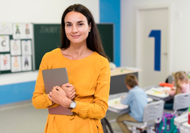 Professor sorridente em pé na sala de aula