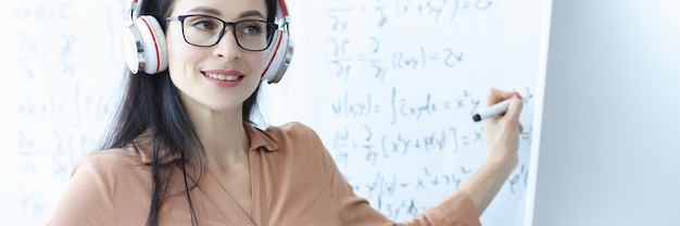 Professora com fones de ouvido dá aula de matemática online