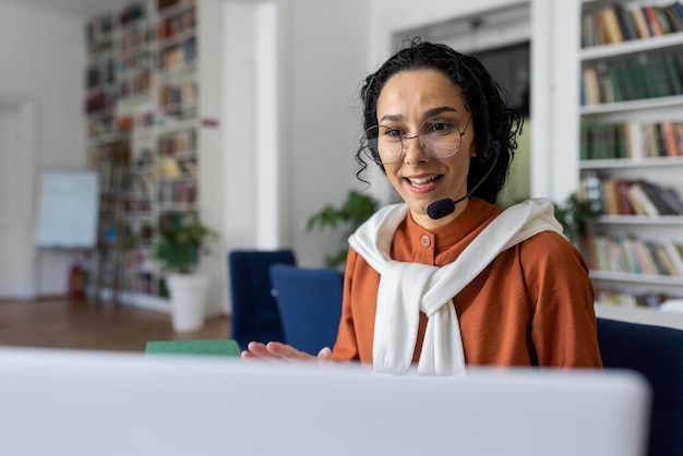 Professora dá aulas online mulher com fone de ouvido de videochamada sorrindo e explicando palestra online