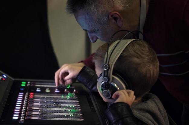 Foto professora de música ajudando um menino a aprender a misturar som em um estúdio de gravação