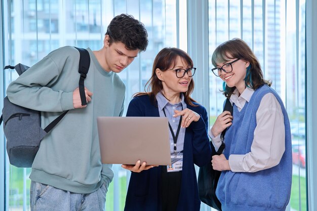 Foto professora e estudante universitária olhando para a tela do laptop.