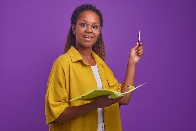 Professora jovem afro-americana detém pasta com papéis e caneta