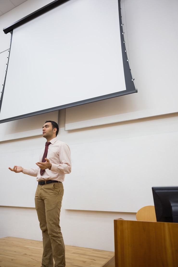 Foto professora masculina contra tela de projeção na sala de aula