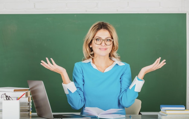 Professora muito jovem do ensino médio ou professora universitária no quadro-negro jovem mulher caucasiana