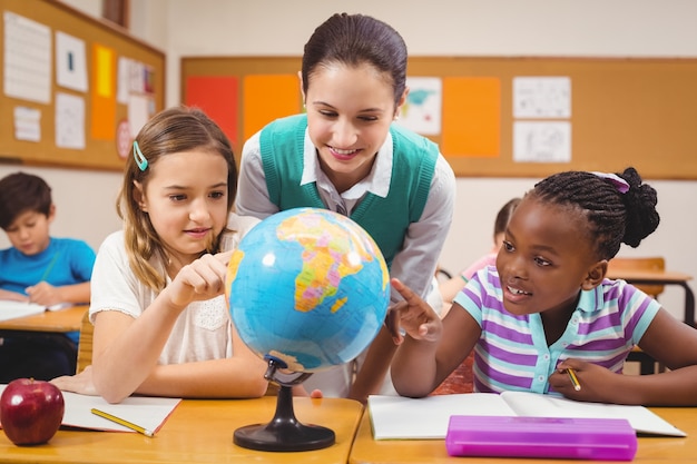 Professores e alunos olhando para o globo