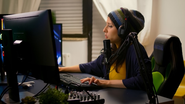 Profi-Streamer, der Online-Videospiele mit RGB-Tastatur, Soundmixer und professionellen Kopfhörern spielt