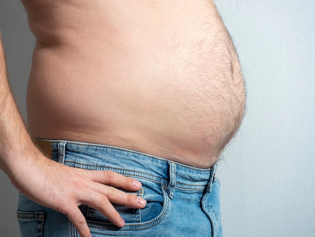 Profil eines dicken Mannes in Jeans. Das Problem der Fettleibigkeit bei Männern.