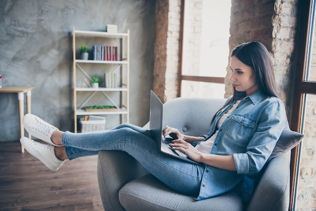 Profilfoto in voller Länge von fokussierten Mädchen Manager haben covid29 Quarantäne Arbeit von zu Hause aus Laptop Online-Kommunikation mit Partnern tragen Jeans-Outfit in Haus Wohnung