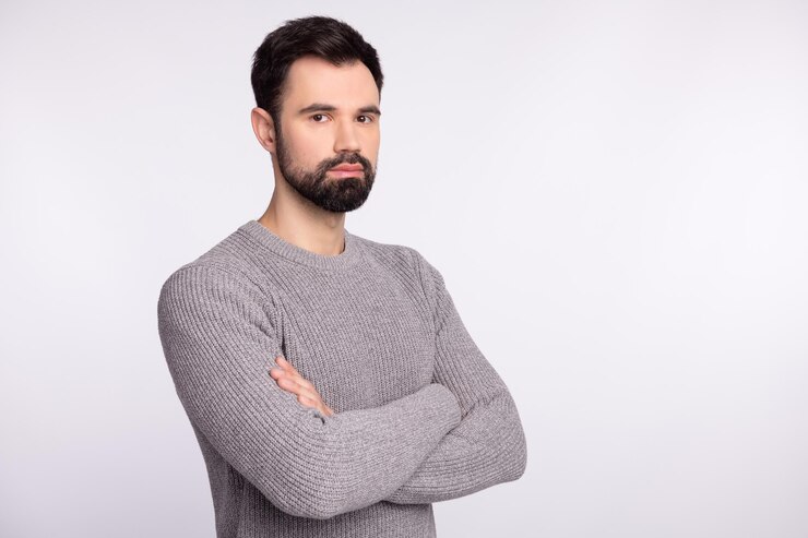 Foto profilseitenfoto eines jungen geschäftsmannes, der selbstbewusste, intelligente gefaltete hände auf grauem hintergrund isoliert