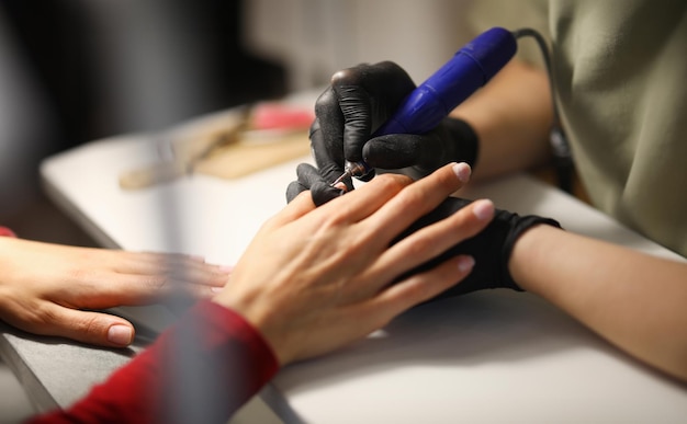 Foto profis in schwarzen handschuhen machen für besucher im studio maschinelle maniküre