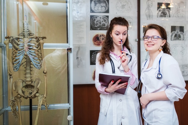 Profissionais de médicos cirurgiões com esqueleto em sala de aula na universidade