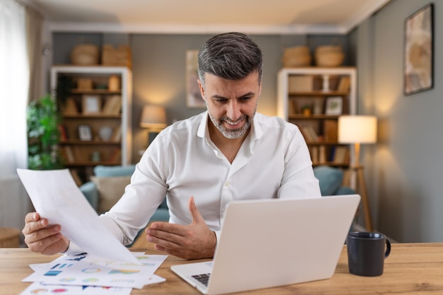 Profissionais de negócios Homem de negócios analisando dados usando computador enquanto passa tempo no escritório Jovem profissional sorridente no escritório Gráficos e gráficos