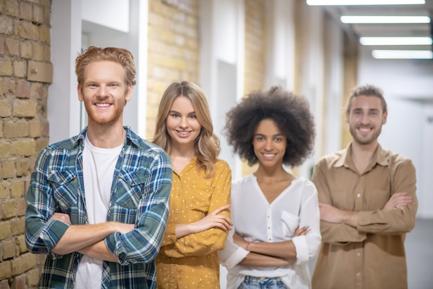 Profissionais jovens. Grupo de jovens profissionais em pé com os braços cruzados e sorrindo