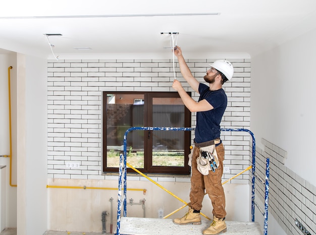 Profissional de macacão com ferramentas de corpo inteiro para reparos. conceito de renovação em casa.