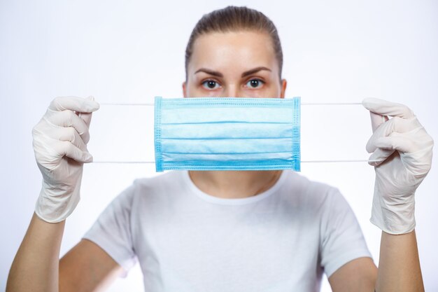 Foto profissional de saúde da mulher em máscara cirúrgica médica protetora contra o vírus. isolado em fundo branco