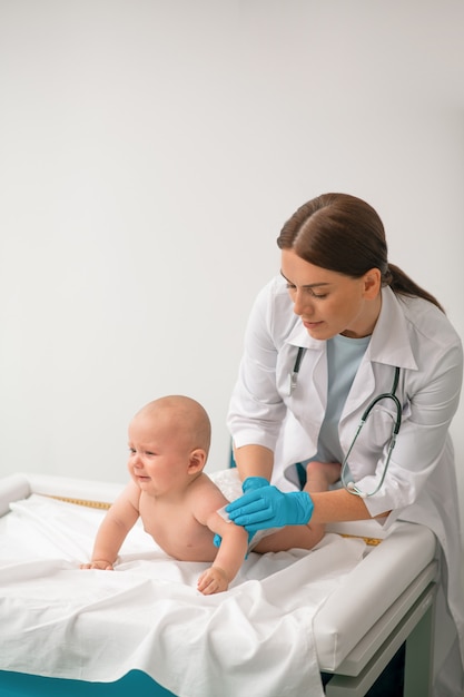 Profissional de saúde experiente preparando uma criança para uma injeção