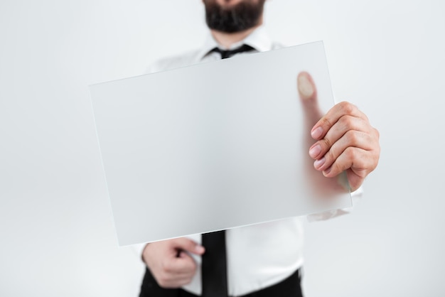 Profissional masculino segurando um cartaz em branco e mostrando um empresário de dados importantes com papel em