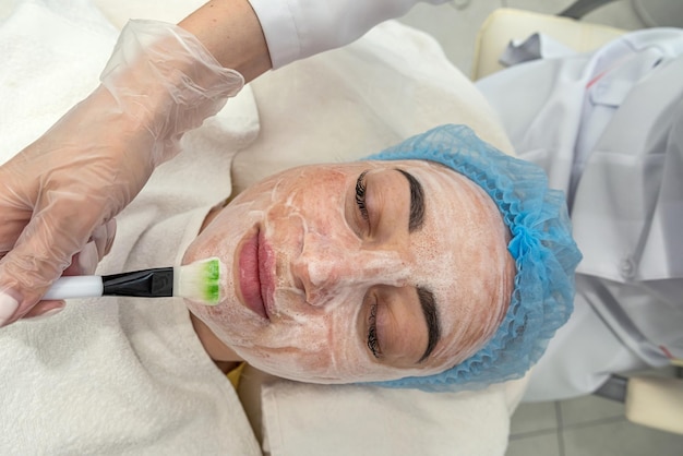 Profissional realiza limpeza ultrassônica da pele do rosto com auxílio de aparelho