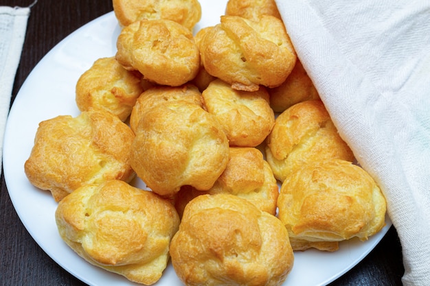 Foto profiteroles caseiros em um prato branco close-up