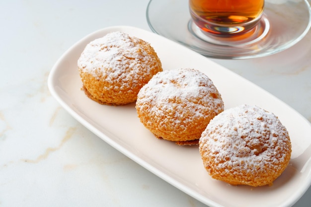 Profiteroles caseros con azúcar en polvo en plato blanco