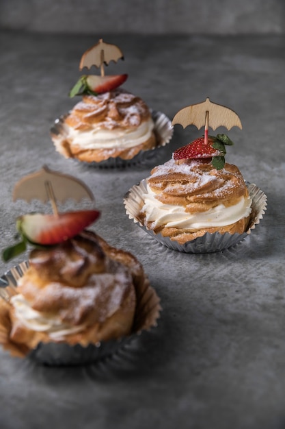 Profiteroles caseros con crema, fresas y menta. Postre para gourmets.