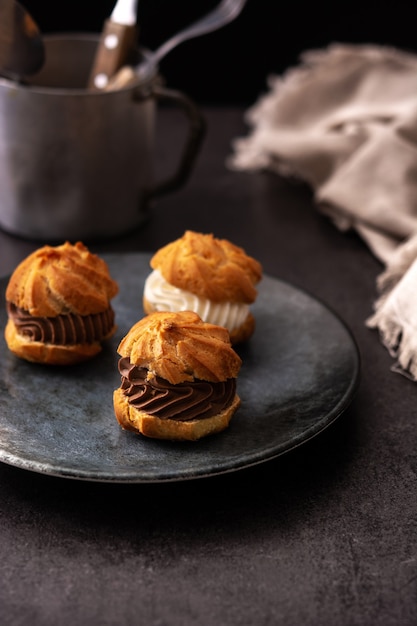 Profiteroles de chocolate y crema sobre fondo negro