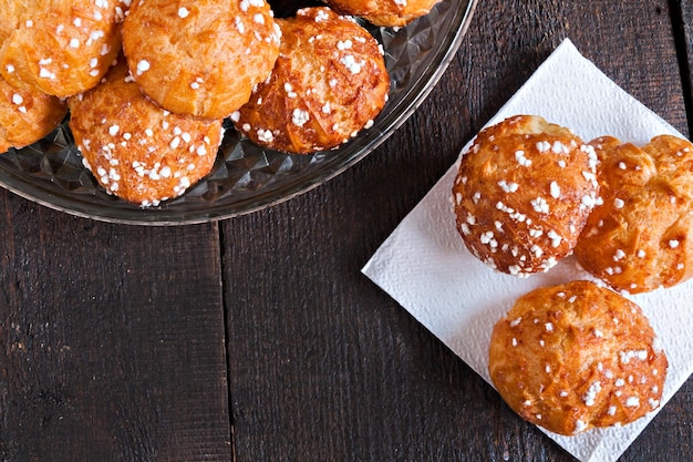 Profiteroles com açúcar polvilhado no fundo escuro