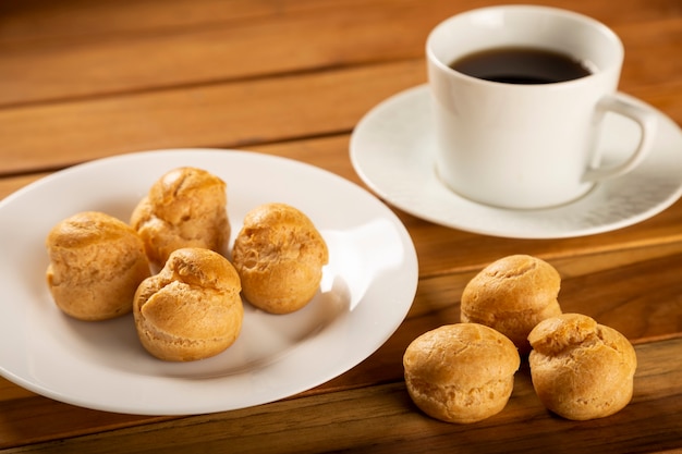 Profiteroles deliciosos con café en la mesa