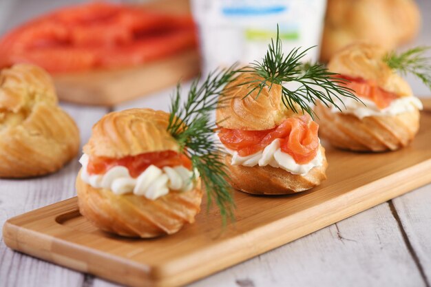 Profiteroles rellenos de queso crema y salmón, decorados con una ramita de eneldo. De cerca