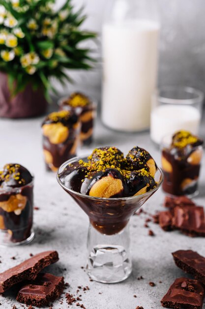 Profiteroles saborosos da sobremesa da culinária francesa com chocolate quente