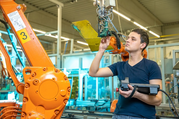 Foto programación de brazos de robot para un nuevo producto por un ingeniero de producción.