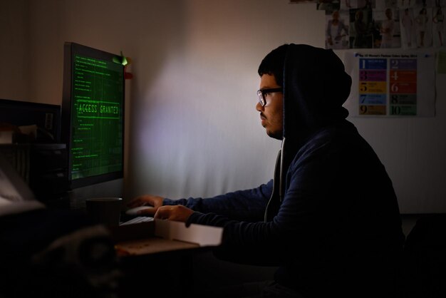 Programación de computadora y hombre con noche de hackers o seguridad cibernética con malware de base de datos en línea o phishing de contraseñas Persona programadora de TI o desarrolladora de ransomware con PC o servidor de sitio web con código