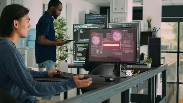 Programador asiático enfocado en escribir código encuentra un error de compilación inesperado, siendo pirateado en la oficina de desarrollo de software. Codificador que tiene fallas en el sistema y trata con piratas informáticos.